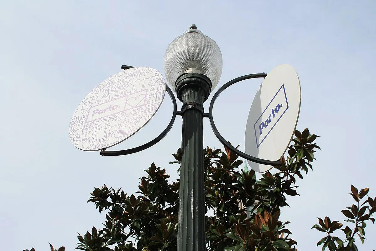 Porto-branded street signs beside a globe-shaped city lamp