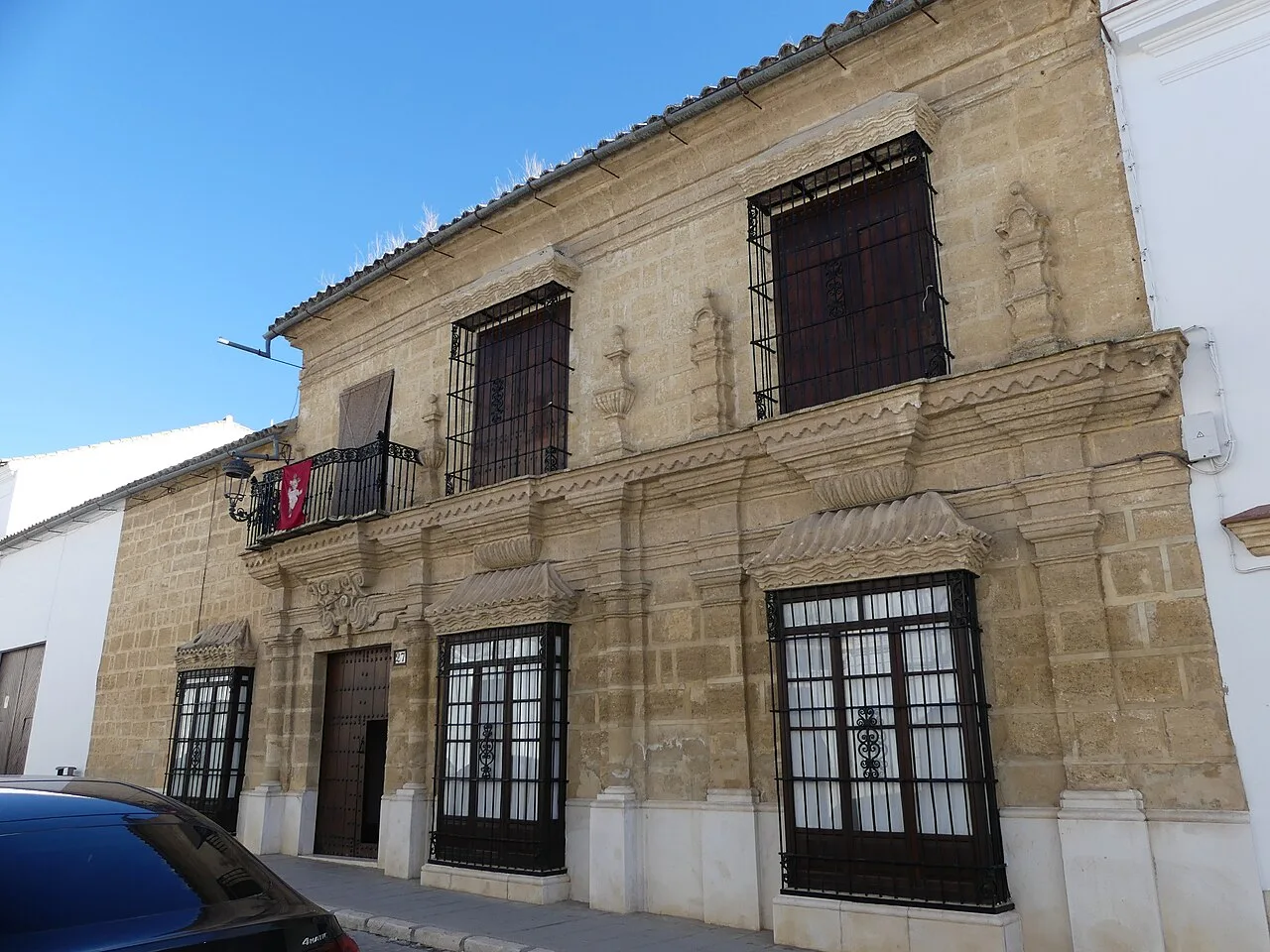 Stone façade and iron balconies at number 27 Calle San Pedro in Osuna
